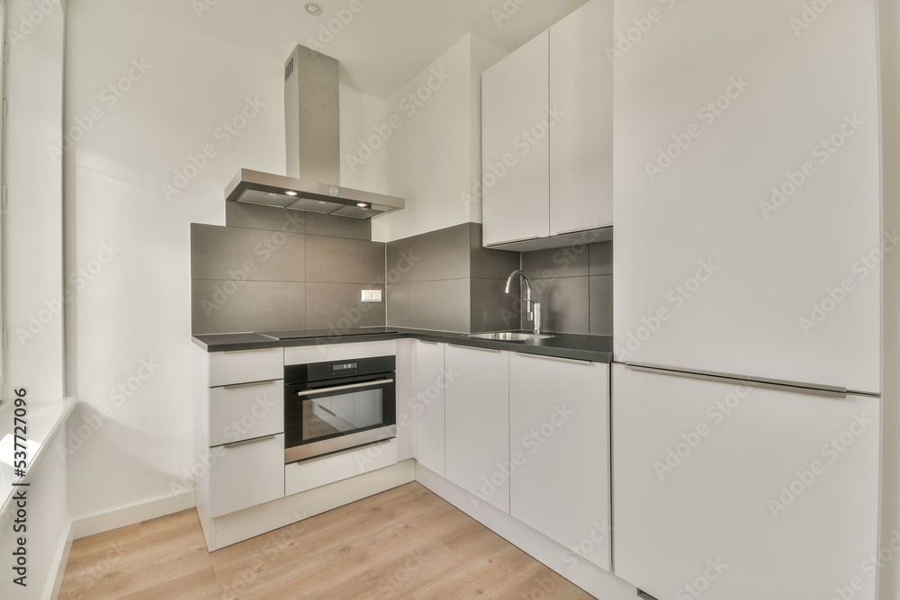 Contemporary kitchen with chrome built in appliances and white cabinets Contemporary kitchen with chrome built in appliances and white cabinets