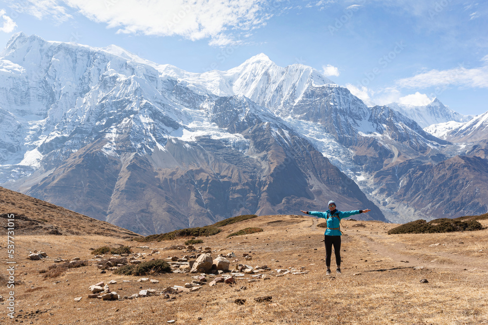 A woman on the Annapurna Circuit, Himalaya, Nepal. Annapurna in the back, covered with snow. Altitude, huge mountains. Freedom