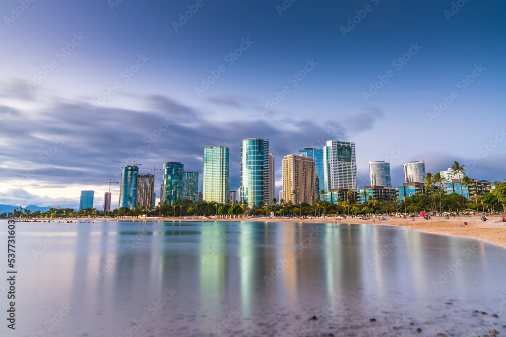 Fototapeta premium hawaii beach with city skyline at sunset.