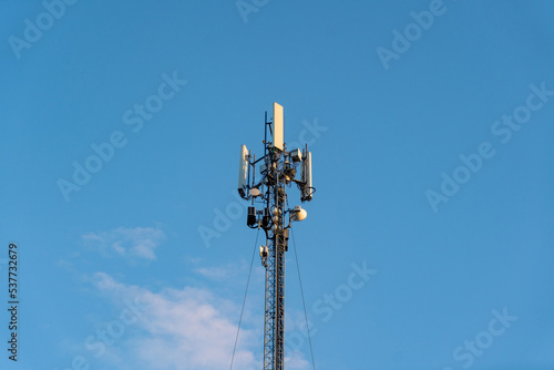 Telecommunications antennas and satellite communication technology. Mobile network on blue sky background.