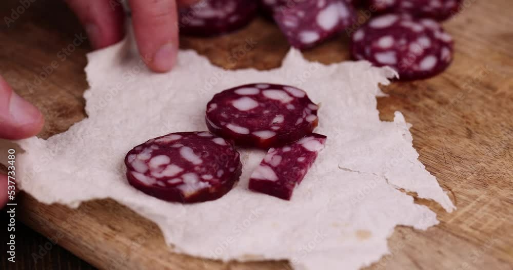 Sliced sausage into thin slices for making sandwiches, pork sausage with bacon during cooking Sliced sausage into thin slices for making sandwiches, pork sausage with bacon during cooking