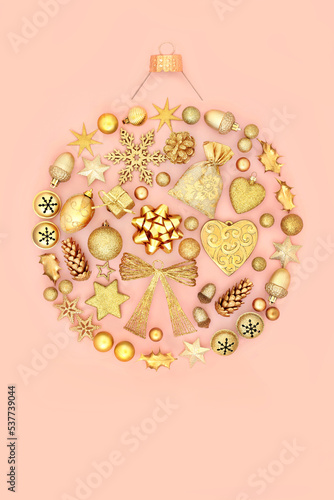 Christmas abstract round shape tree decoration concept with gold decorations and symbols on pastel coral pink background. Festive design for the holiday season. Flat lay.