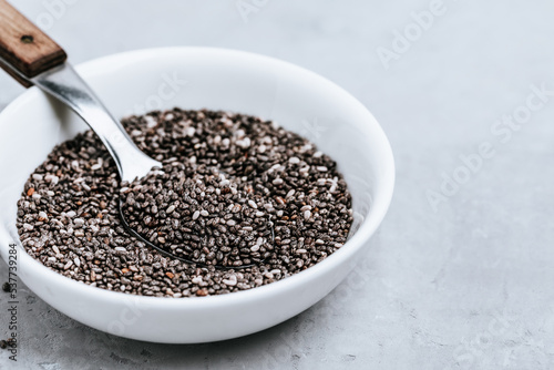Chia seeds. Organic Dry Black and White Chia Seeds in bowl on gray stone background