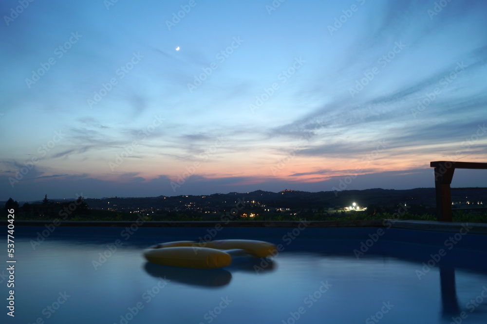 Vista panoramica di tramonto sulle colline con acqua di piscina privata in primo piano