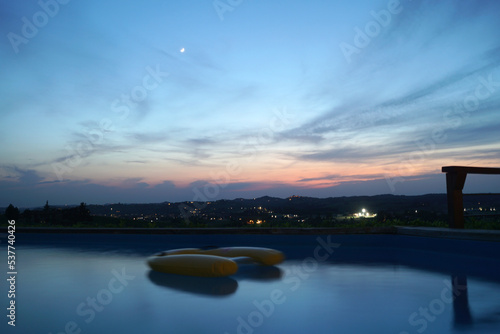 Vista panoramica di tramonto sulle colline con acqua di piscina privata in primo piano photo