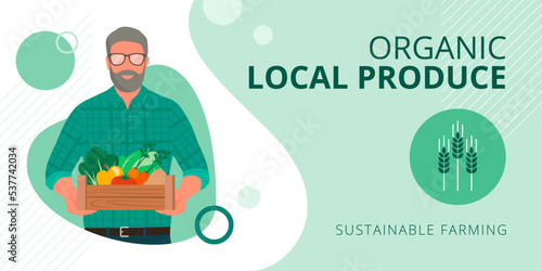 Traditional senior farmer holding a crate with fresh organic produceee