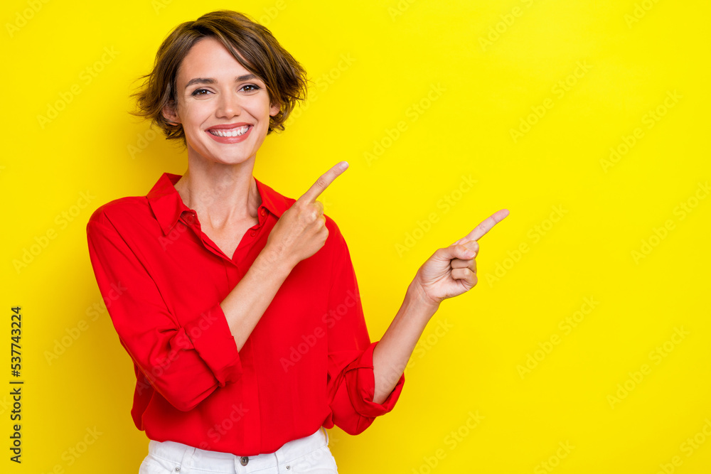 Photo of adorable gorgeous girl with bob hairstyle wear red shirt fingers directing empty space isolated on yellow color background Photo of adorable gorgeous girl with bob hairstyle wear red shirt fingers directing empty space isolated on yellow color background