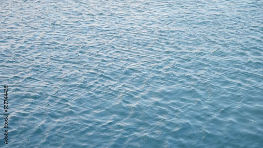 Slow motion blue sea or ocean water moving in the wind with waves. Peacefully waters in ocean or marine harbor. Top shot or overhead shot of salt or sweet water Slow motion blue sea or ocean water moving in the wind with waves. Peacefully waters in ocean or marine harbor. Top shot or overhead shot of salt or sweet water