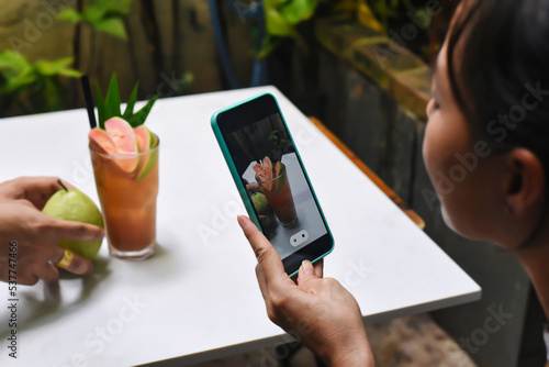 A woman taking picture of guava tea for advertisement and social media
