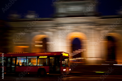 Public transport bus circulating in front of the Puerta de Alcalá in the city of Madrid photo