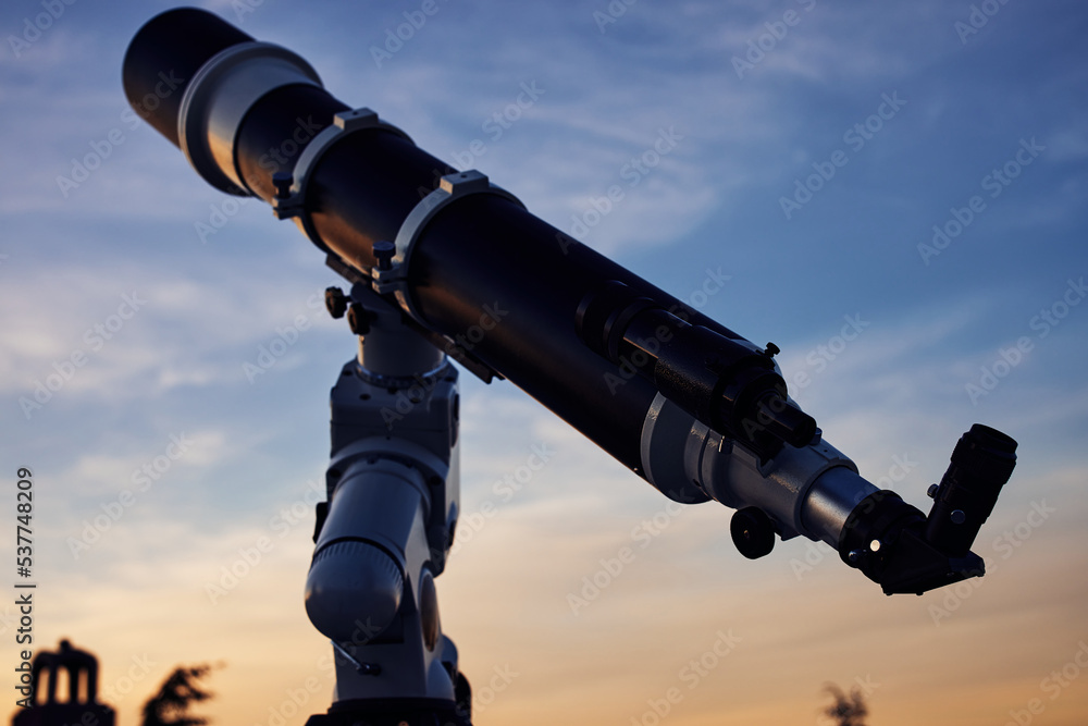 Big astronomical telescope under a twilight sky ready for stargazing. Big astronomical telescope under a twilight sky ready for stargazing.