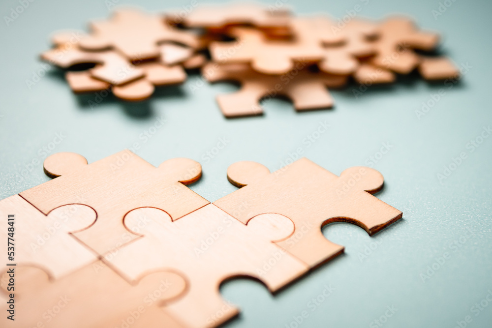 Obraz premium Wooden puzzles jigsaw solving problems in business. Innovation and teamwork in the company with copy space.