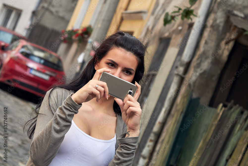 Young cute female using smartphone on the street. Young cute female using smartphone on the street.