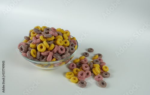 Cornflakes rings in a glass plate on a white background, close-up. 