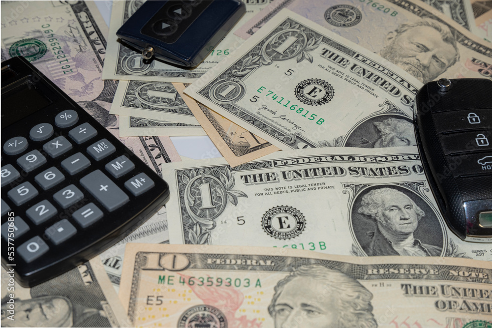 car keys and canculator on the photo of money. calculate the cost of a car trip car keys and canculator on the photo of money. calculate the cost of a car trip