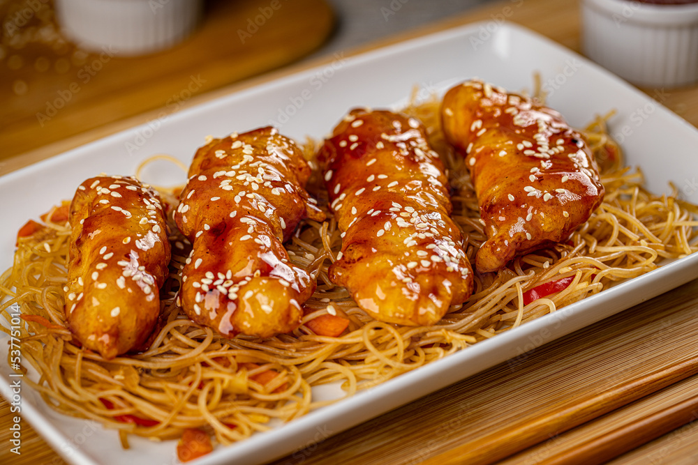 Sticky chicken served with noodles Sticky chicken served with noodles