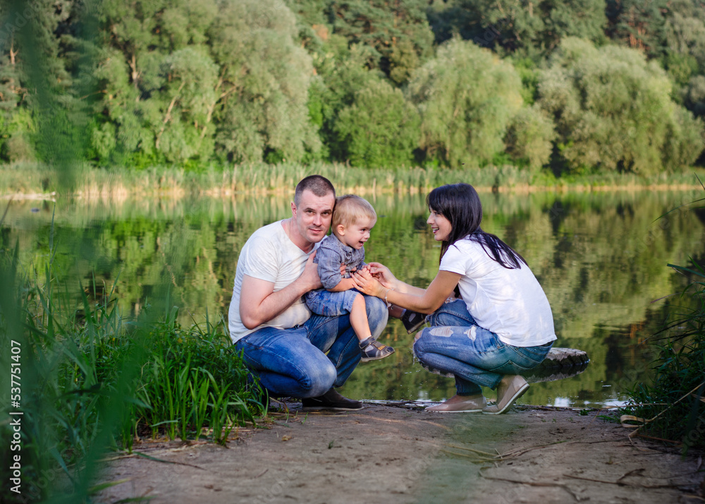 Beautiful happy Ukrainian family in the forest in summer. Mom, dad and son 2 years old in the forest. Beautiful happy Ukrainian family in the forest in summer. Mom, dad and son 2 years old in the forest.