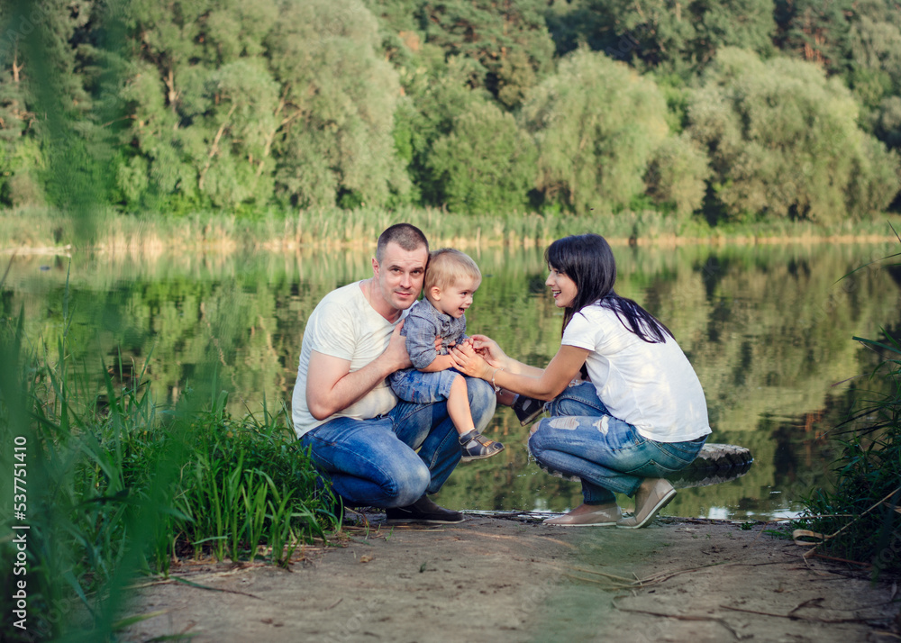 Beautiful happy Ukrainian family in the forest in summer. Mom, dad and son 2 years old in the forest. Beautiful happy Ukrainian family in the forest in summer. Mom, dad and son 2 years old in the forest.