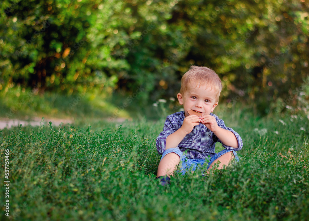 Boy 2 years old eats chocolate in nature. A child covered in chocolate. Boy 2 years old eats chocolate in nature. A child covered in chocolate.