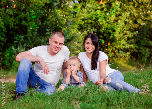 Beautiful happy Ukrainian family in the forest in summer. Mom, dad and son 2 years old in the forest.