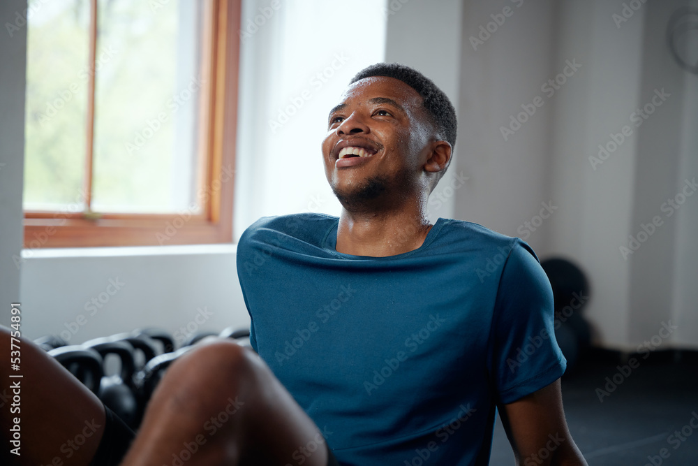 Confident young black man taking a break between exercises at the gym Confident young black man taking a break between exercises at the gym