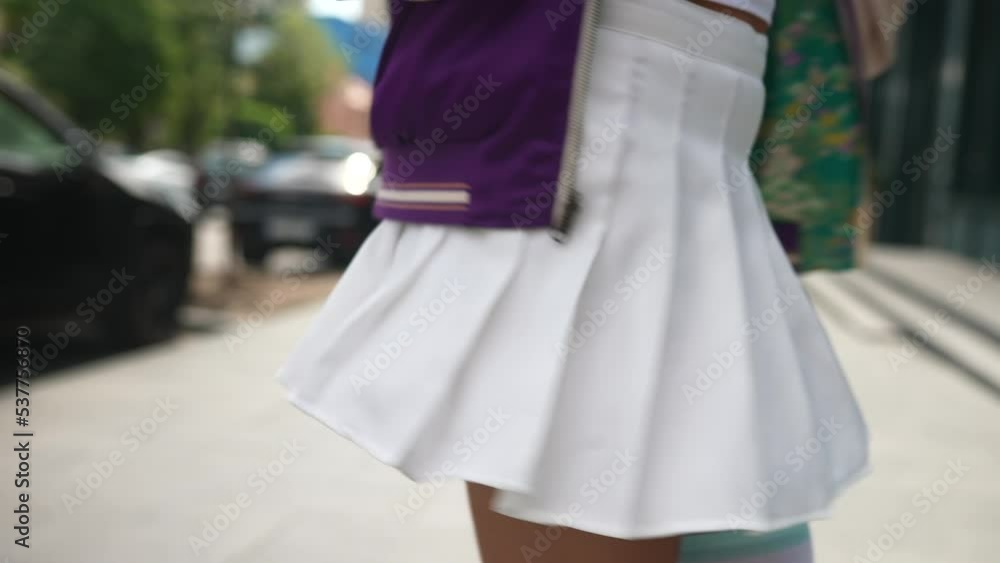 A young woman spins in a short skirt on the street A young woman spins in a short skirt on the street