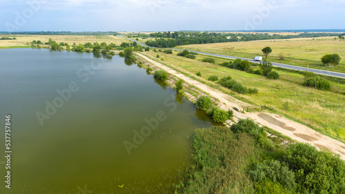 Top view of a motor road along the lake on a summer day