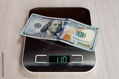 Dollar bills on electronic scales, a symbol of cost appreciation, deflation, overestimation of money. concept of inflation in the United States of America. photo