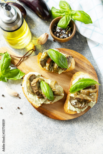 Open sandwiches set with grill aubergine and cream cheese on a stone table. Healthy food, vegetarian appetizer. Copy space.