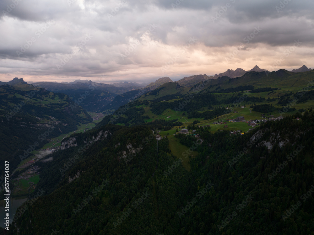Swiss mountain village Stoos at sunset aerial drone overview in canton of Schwyz. Hiking village near Fronalpstock ridge hike. Resort and hiking adventure landscape.