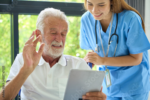 Home healthcare service, Nurse advide the oldy man use tablet for teleconference with doctor photo