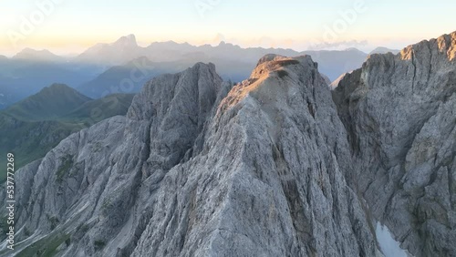 Aerial video of the sunrise in the Dolomites mountains. It was shot on the beautiful meadows of Seiser Alm plateau with fog and mist in the morning. photo