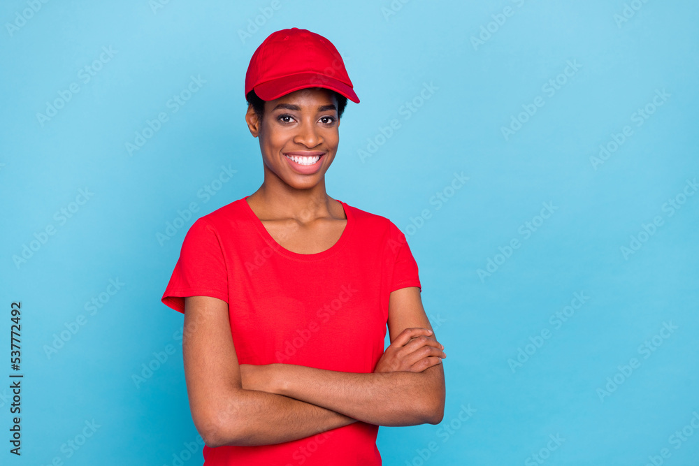 Photo of cheerful good mood short hair person dressed red uniform t-shirt cap arms crossed empty space isolated blue color background Photo of cheerful good mood short hair person dressed red uniform t-shirt cap arms crossed empty space isolated blue color background