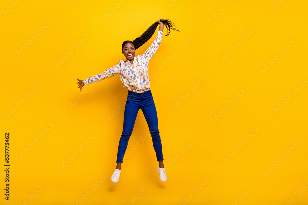 Full length body size view of attractive cheerful girly girl jumping holding tail isolated over bright yellow color background Full length body size view of attractive cheerful girly girl jumping holding tail isolated over bright yellow color background