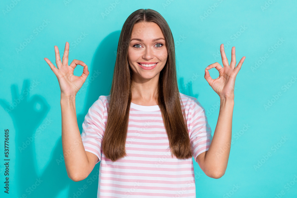 Photo of good mood optimistic girl with long hairstyle wear striped t-shirt showing okey symbol isolated on turquoise color background Photo of good mood optimistic girl with long hairstyle wear striped t-shirt showing okey symbol isolated on turquoise color background