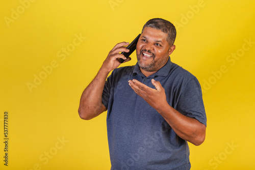 Brazilian black man, adult talking on cell phone, voice call. photo