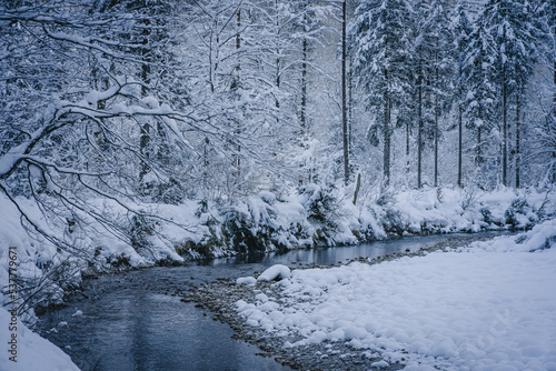 snowy winter landscape crossed by a river 