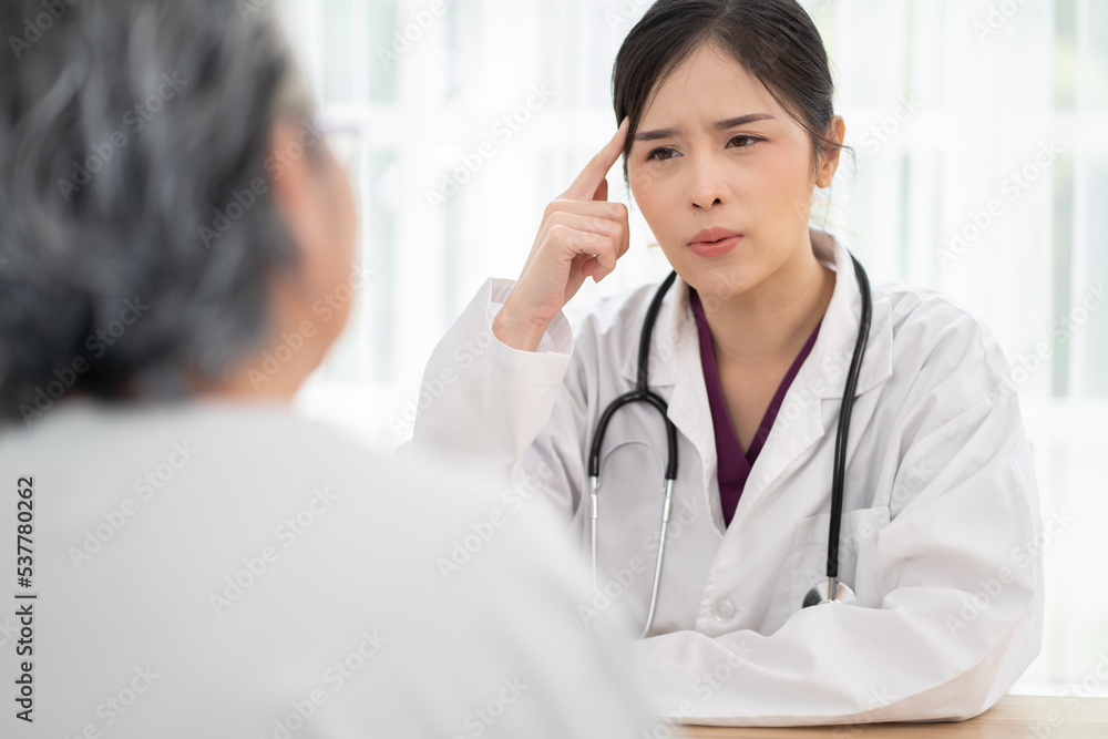 Young female doctor hanging stethoscope care senior woman by talking and helping her with medical treatment consultation at hospital. General practitioner sitting at clinic with an elderly pensioner. Young female doctor hanging stethoscope care senior woman by talking and helping her with medical treatment consultation at hospital. General practitioner sitting at clinic with an elderly pensioner.