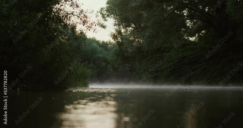 Fog on mountain river. Golden sunlight rising moving orange mist on water surface Forest background and beautiful peaceful reflections Fog on mountain river. Golden sunlight rising moving orange mist on water surface Forest background and beautiful peaceful reflections