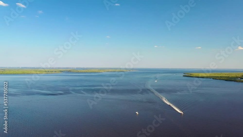 View of boats sailing in Myakka River under blue sky, tropical island, near Port Charlotte, Florida photo
