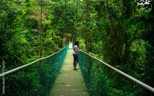 Young girl on suspension bridge with forest background in Central America photo
