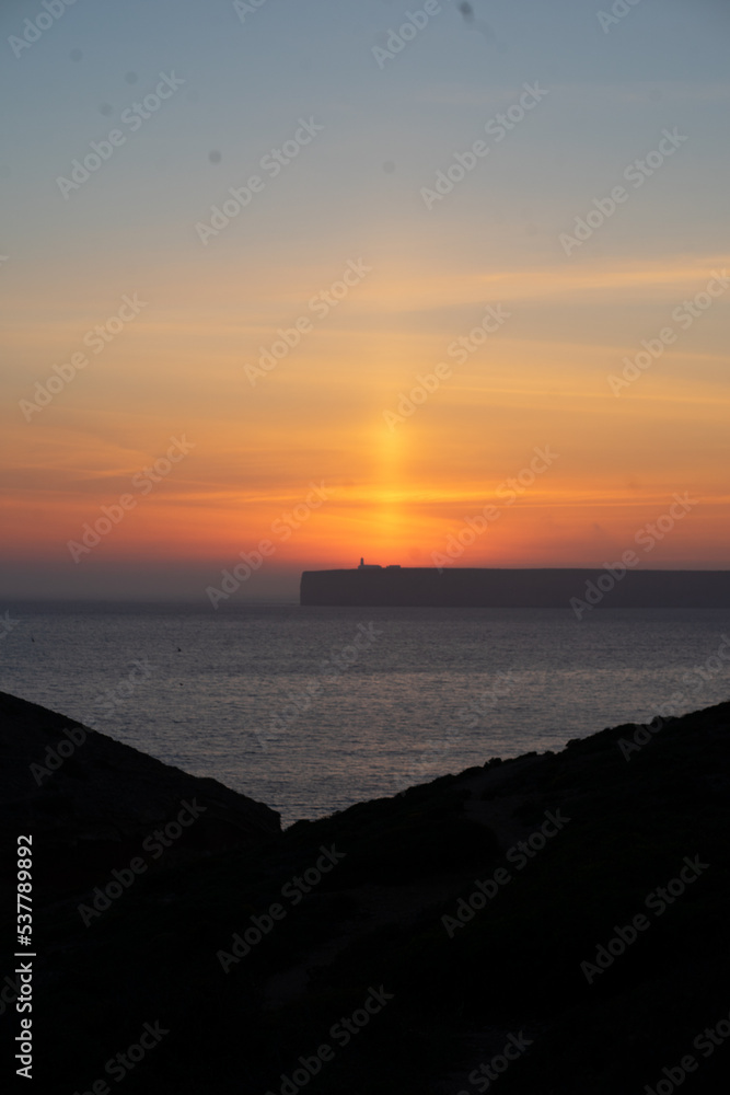 mystical sunset by the sea with a section of coast	