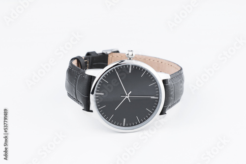 Closeup luxury man wrist watch black dial on gray fabric background. Dark toned.