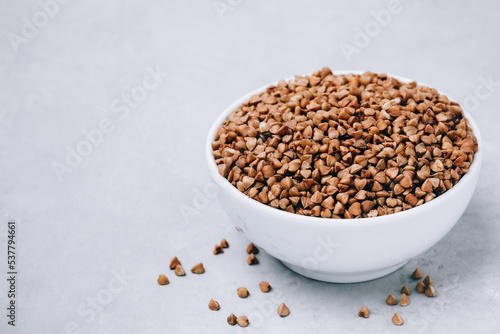 Buckwheat. Organic raw dry Buckwheat grains in bowl on gray stone background.