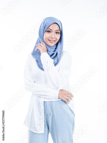 Portrait of a beautiful Muslim female model wearing modern and stylish casualwear with hijab isolated white studio background. Modern hijab fashion and beauty concept © HEMINXYLAN