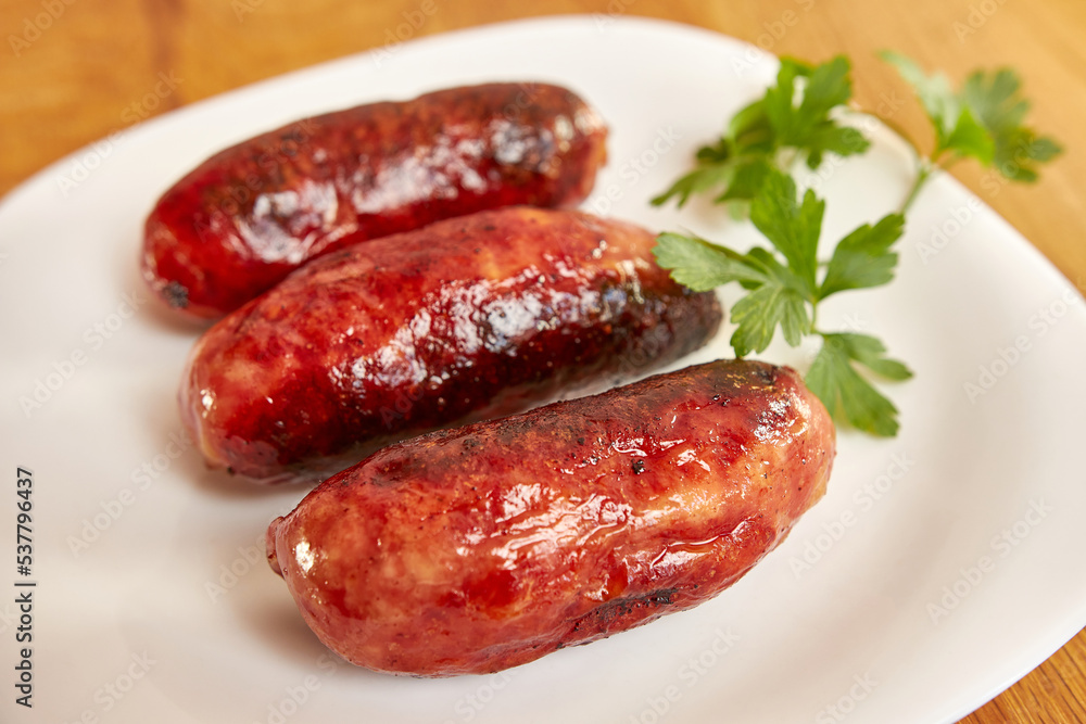 Fried sausages on a white plate. Fried sausages on a white plate.