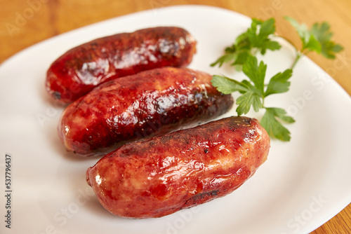 Fried sausages on a white plate.