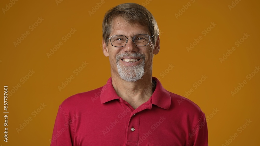 Smiling bearded mature man 50s 60s years old wearing red shirt isolated on solid yellow background studio. People sincere emotions lifestyle concept. Looking camera. Smiling bearded mature man 50s 60s years old wearing red shirt isolated on solid yellow background studio. People sincere emotions lifestyle concept. Looking camera.