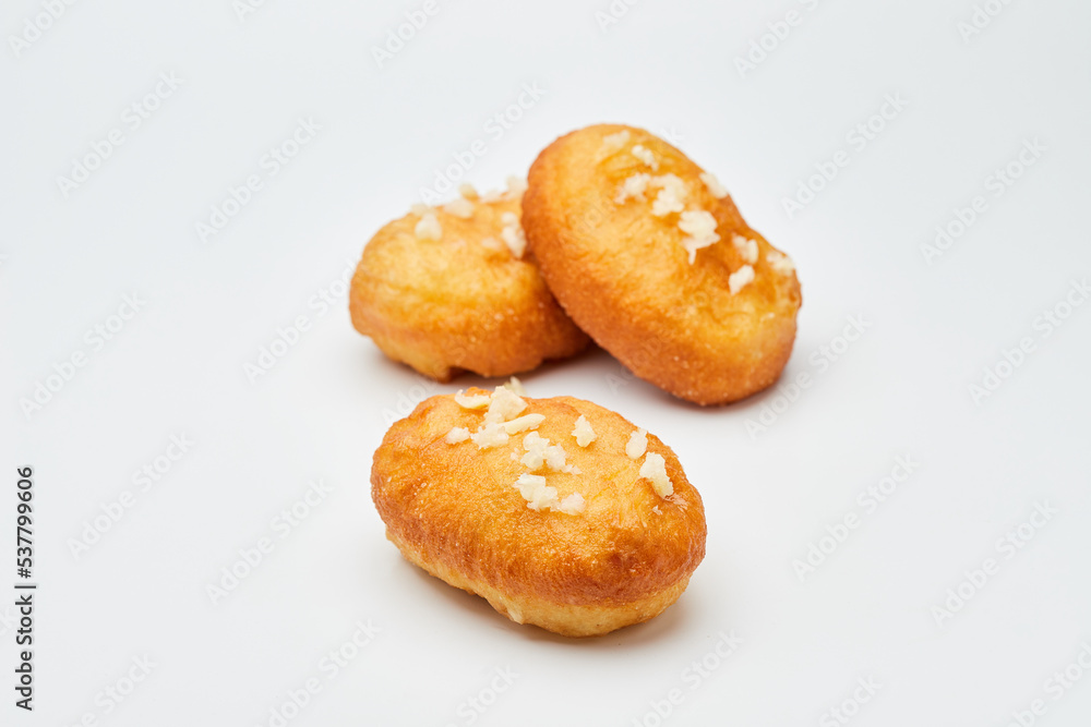 Tasty fried donuts with peas and garlic isolated on white background. Unhealthy food. Studio shoot