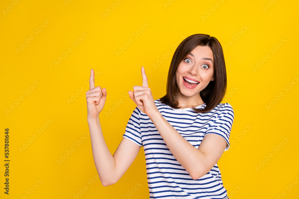 Photo of young attractive pretty funny woman finger directing empty space good new retail price reaction isolated on yellow color background Photo of young attractive pretty funny woman finger directing empty space good new retail price reaction isolated on yellow color background